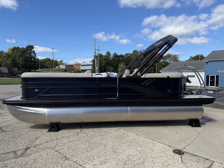 Bennington 21 SSR pontoon boat with black and silver design on a paved lot.