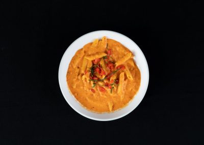 Close-up of flavorful Indian curry with vegetables in a white bowl.