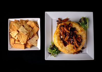 Asian dish with crispy fried fish topped with mushrooms and onions, served with crispy wonton chips.