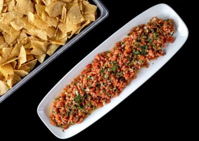 Close-up of a seasoned minced meat dish on a white plate with tortilla chips.