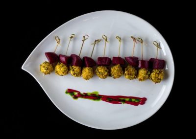 Appetizer platter with skewers of meat and vegetables on a white plate.