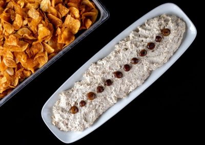 Food product with a creamy texture and toppings on a white dish.