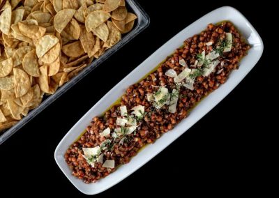 Delicious nacho dip with seasoned ground beef and cheese on a white platter.
