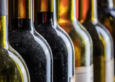 Row of wine bottles with condensation, showcasing quality and freshness.