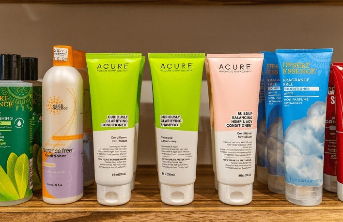 Collection of Healthy Roots hair care products on wooden shelf.
