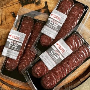 Premium Wagyu Big Red Salame from Smoking Goose on a wooden surface.