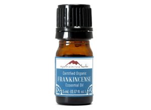 Small amber glass bottle of frankincense essential oil with black cap.