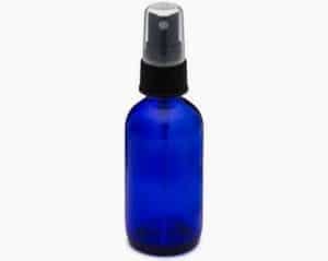 Blue glass spray bottle with mister for skincare or aromatherapy.