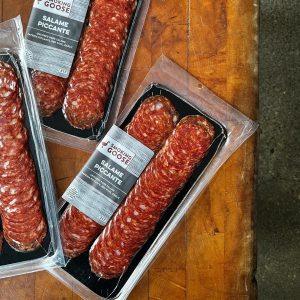 Spicy salami slices from Smoking Goose in clear plastic tray.