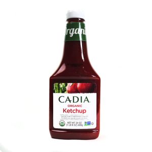 Organic ketchup bottle with red sauce and green label from Cadia.