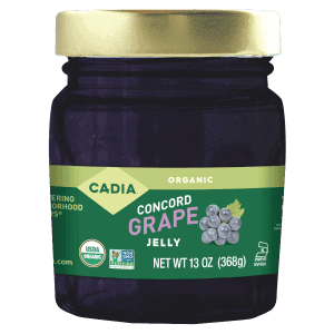 Organic Concord grape jelly jar with gold lid, healthy roots branding, and grape illustration.