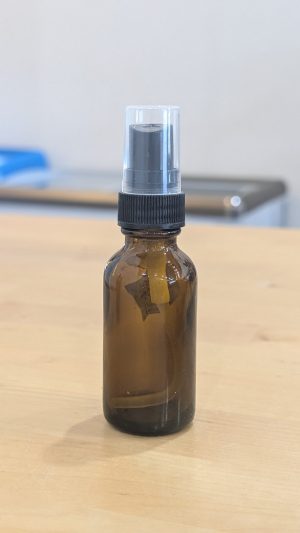 Small amber glass spray bottle with black spray top for essential oils or liquids.