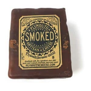 Plymouth Smoked Cheddar cheese with artisan label and natural rind.