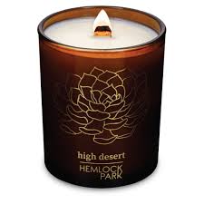 High Desert Hemlock Park candle with floral design and warm glow.