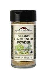 Organic fennel seed powder in a clear glass jar with black lid.
