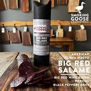 Smoked Big Red Salame from Smoking Goose on a wooden surface.