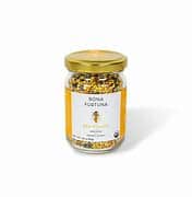 Healthy Roots bee pollen jar with golden lid and label on white background.