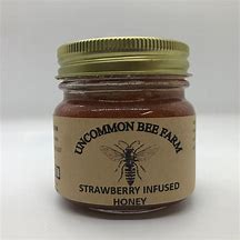 Strawberry infused honey jar from Uncommon Bee Farm with gold lid.