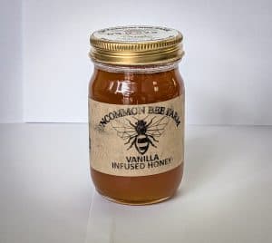 Jar of vanilla infused honey from Uncommon Bee Farm with a gold lid and label.