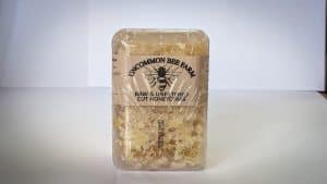 Uncommon Bee honeycomb in a clear plastic container with label.