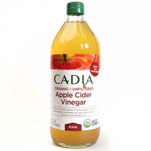 Organic apple cider vinegar bottle with green cap and label details.