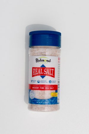 Redmond Real Salt shaker with pink sea salt for cooking and seasoning.