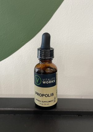 VITALITY WORKS Propolis supplement bottle with dropper on black surface.
