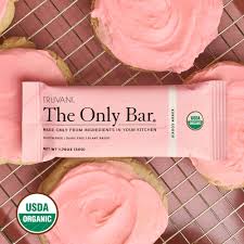 Truvani Sugar Cookie Protein Bar on cooling rack with pink frosting.