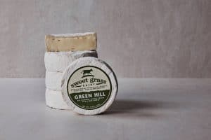 Fresh Green Hill cheese from Sweet Grass Dairy on a neutral background.