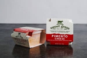 Sweet Grass Dairy Pimento Cheese packaging on a dark surface.