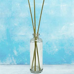 Glass diffuser bottle with reed sticks for essential oils or fragrances.