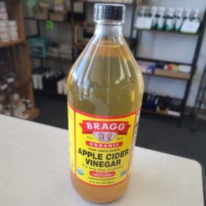 Bragg's organic apple cider vinegar bottle on store counter.