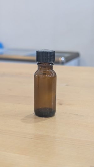 Small amber glass bottle with black cap for essential oils or liquids.