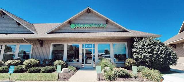 Michigan real estate office located in Lake Shore with prominent HomeReality branding and well-maintained landscaping.