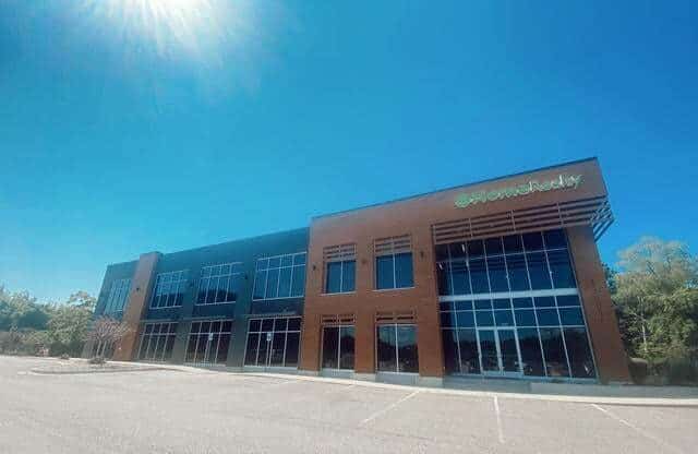 HomeReality Michigan real estate office building with modern glass facade and brick exterior, showcasing a prime location for property listings and real estate services in Michigan.
