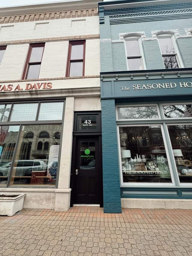 HomeRealty Michigan real estate office on a downtown street, showcasing historic buildings and retail storefronts, ideal for those seeking property listings, homes for sale, and real estate services in Michigan.