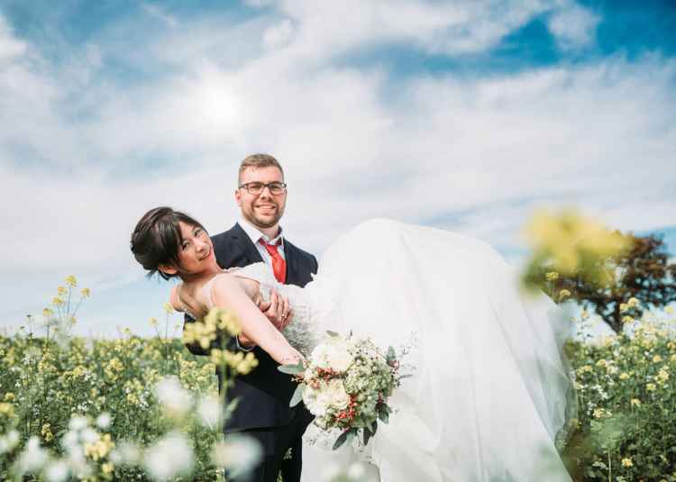 Hochzeitsfoto im Rapsfeld bei Sonnenschein