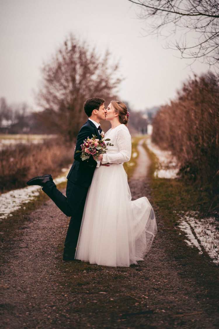 Brautpaar streckt die Beine lustig nach oben beim Hochzeitsshooting nach der Hochzeit