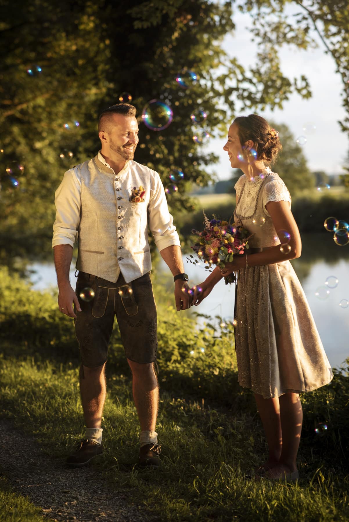 Brautpaar beim Hochzeitsshooting an einem See in Thierhaupten, umgeben von Seifenblasen