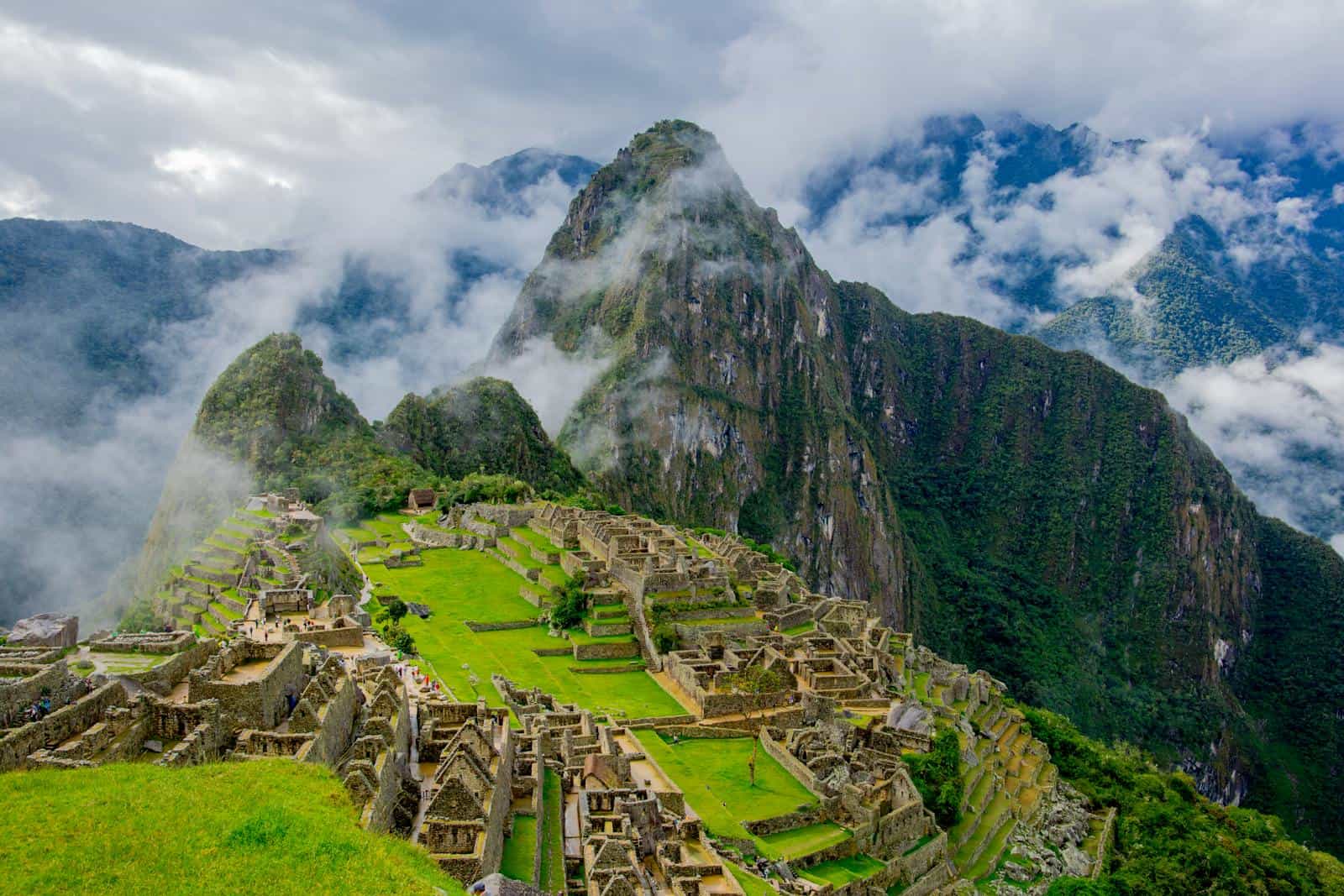 Stunning aerial view of Machu Picchu ruins surrounded by lush mountains and mist.