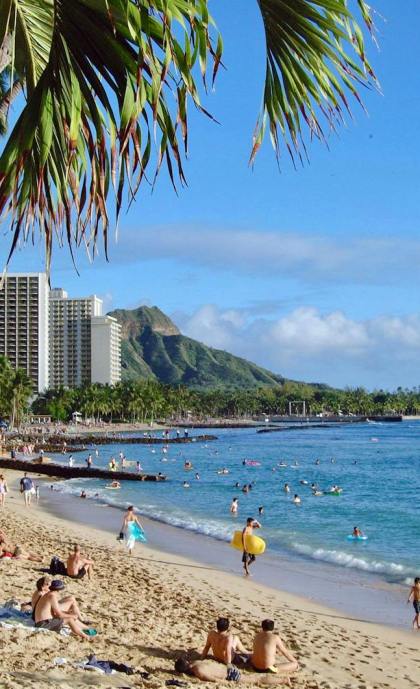 Vibrant scene of people enjoying Waikiki Beach under the tropical sun in Oahu, Hawaii. Travel to Hawaii.