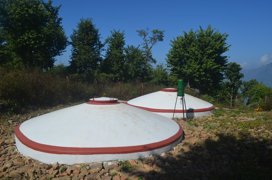 The two round water storage tanks, painted white with red trim.