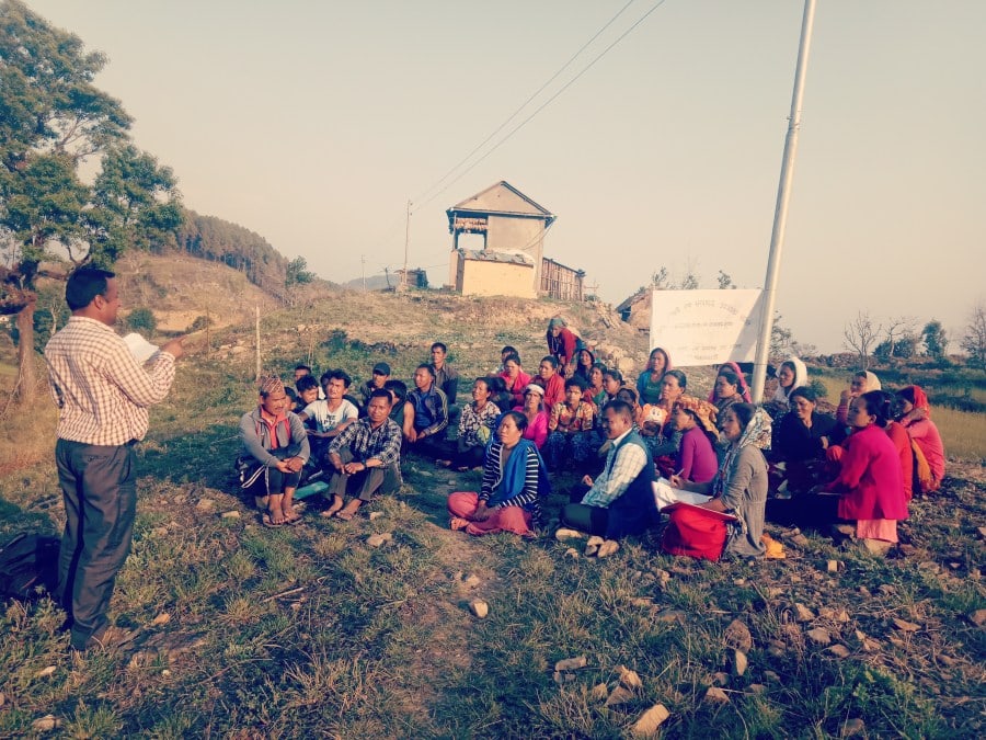 Training on water resource management and health and safety, led by a project worker, with many community members. 