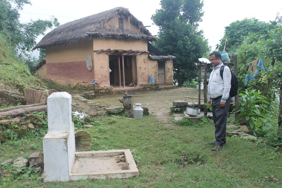 A project worker looks at the completed water tap. 