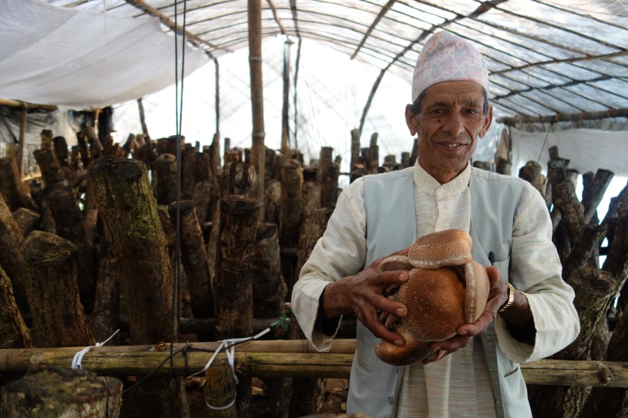 A Sirubari man holding locally grown food.