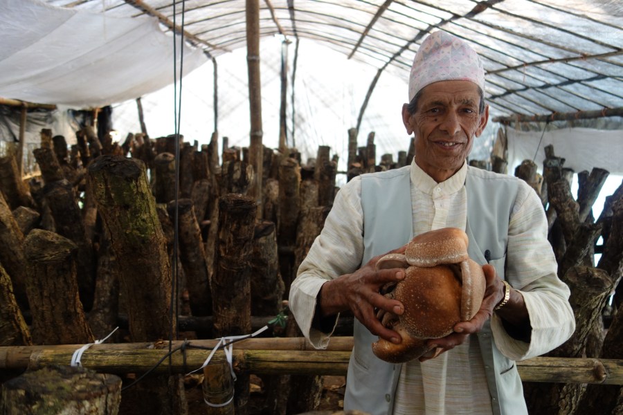 A Sirubari man holding locally grown food. 