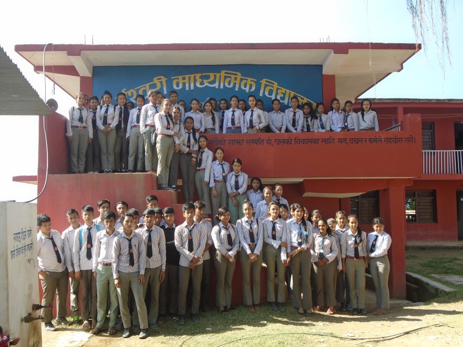 Students of the Ishwori Secondary School line up for a photograph in front of the school building.