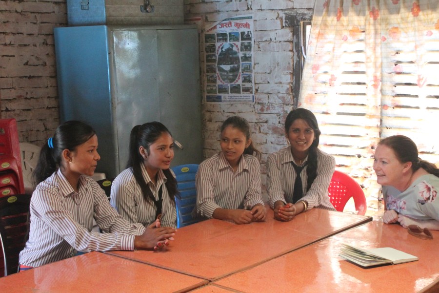 Urmila, Nurita, Deepa and Manisha sit and join in conversation in the classroom. 