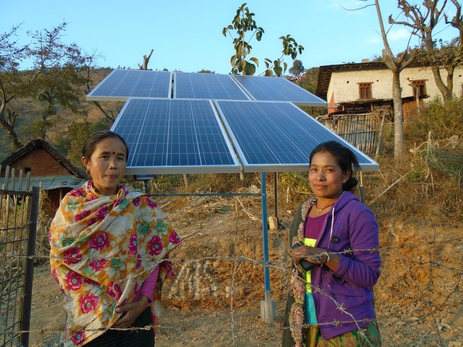 Nuna and a friend standing in front of the solar-powered water pumping system. 