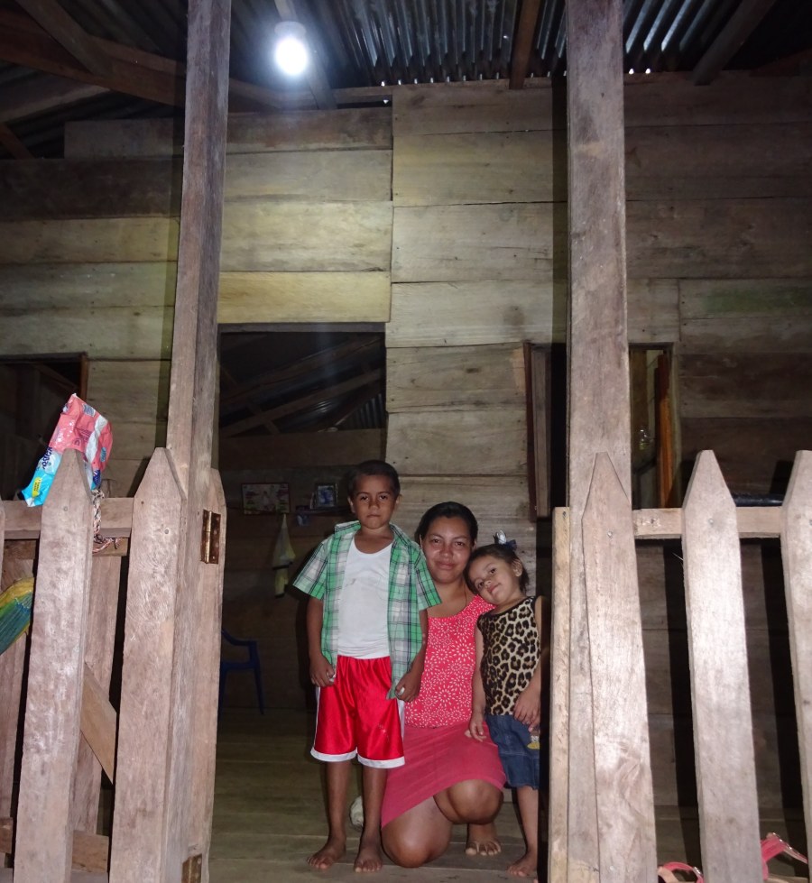 Maricela and her children outside their home